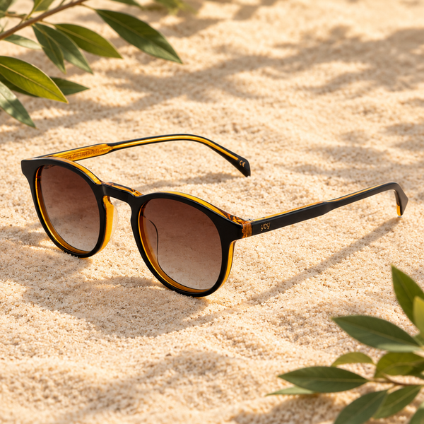 Lunettes de soleil Mirabelle posées sur du sable dans un décor naturel