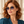 Load image into Gallery viewer, Femme portant les lunettes Nèfle aux tons miel et brun ambre
